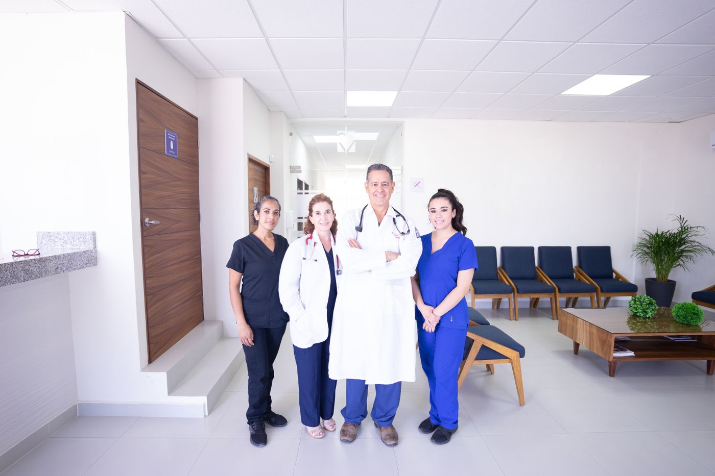 Equipe de médicos e enfermeiras sorrindo na recepção do hospital